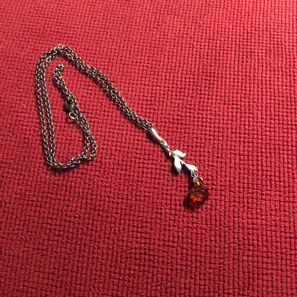 A sliver necklace with a rose pendent